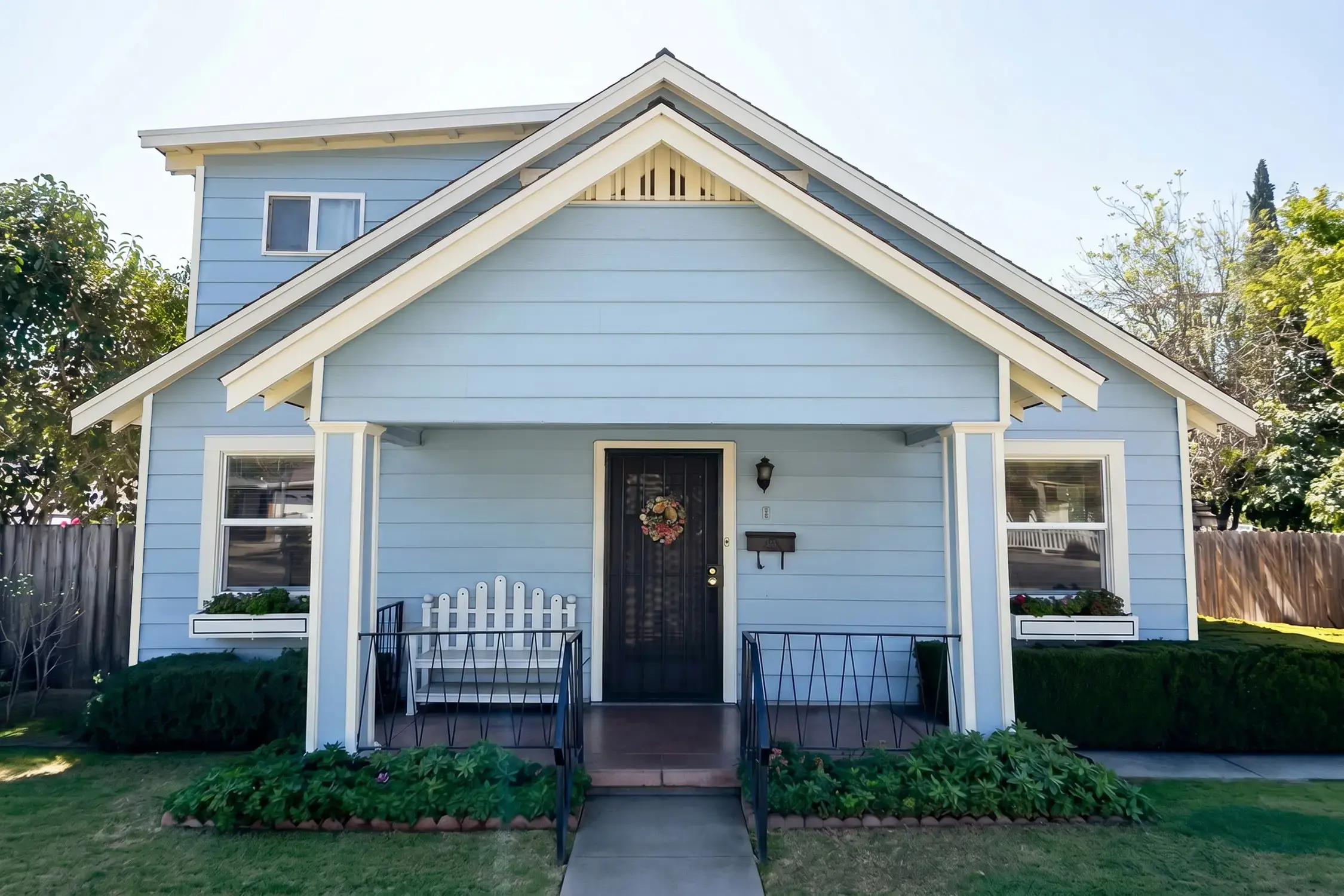 Blue-gray lap siding and white trim after a Hybrid Renovations exterior repaint on a craftsman bungalow in Claremont
